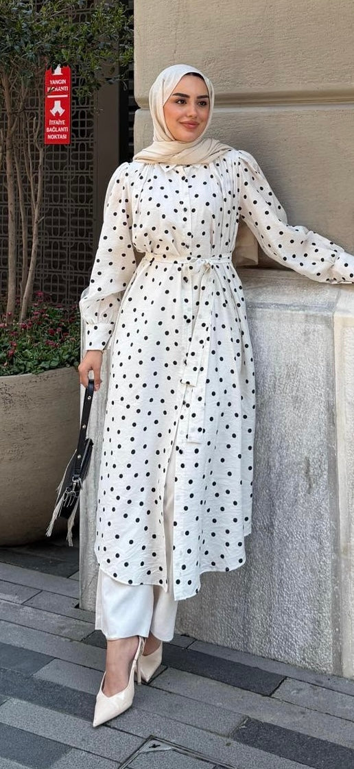 Polka dot cotton tunic in ivory with black dots, styled with wide-leg pants and heels