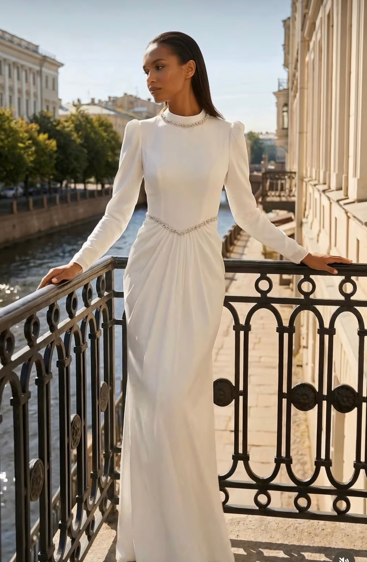 White modest bridal dress with crystal neckline and waist embellishment, long fitted sleeves and slim draped skirt