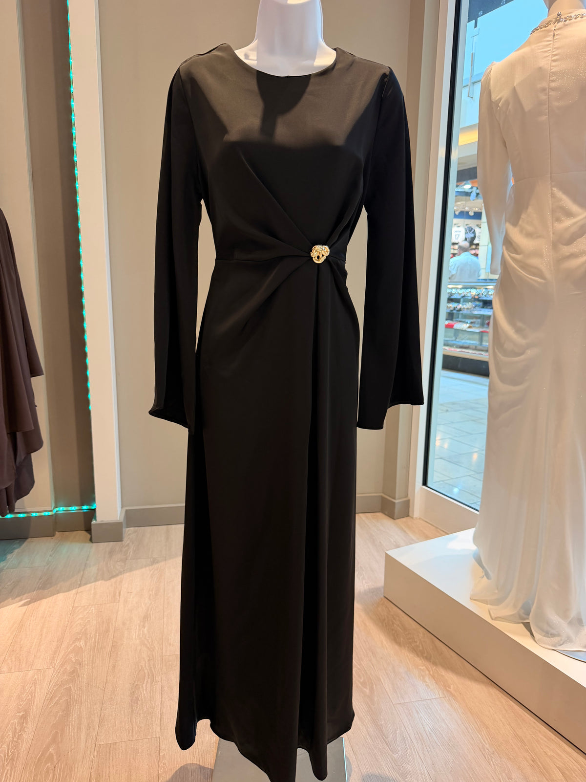 Black satin silk maxi dress with gold brooch waist detail on mannequin